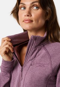Veste polaire violette à demi-zip avec un motif texturé, dotée d'un col haut, d'une fermeture éclair et d'un logo brodé sur la poitrine.