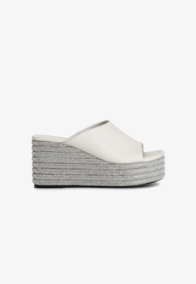 Sandali con tacco a zeppa aperti bianchi, con una piattaforma argentata intrecciata e robusta. Parte superiore liscia con un design elegante e dettaglio del tacco testurizzato.