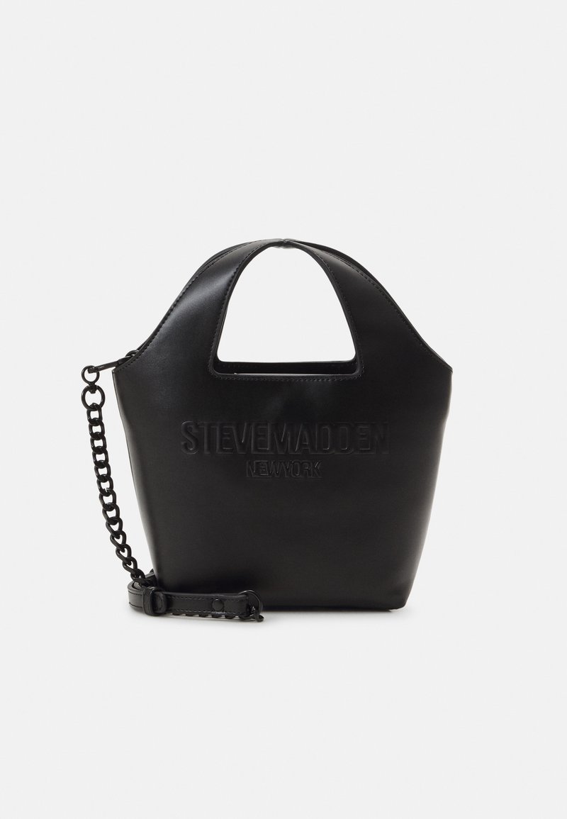 Sac noir Steve Madden avec des poignées découpées, logo embossé et bandoulière en chaîne amovible sur fond blanc.