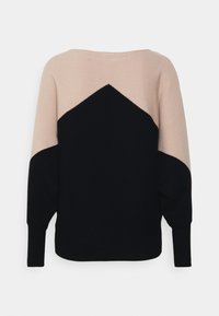 Knitted sweater with a loose fit, featuring a color block design in beige and navy. Ribbed texture, wide sleeves, and boat neckline.