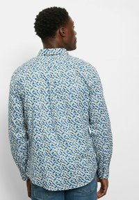 Hemd aus Baumwolle mit einem blau-grün-gelben Blumenmuster, ausgestattet mit langen Ärmeln und einem Hemdkragen mit Knöpfen.