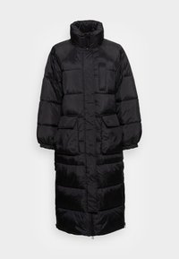 Cappotto puffer nero con colletto alto, chiusura con zip, due tasche frontali e design lungo fino al ginocchio con cuciture orizzontali per l'isolamento.