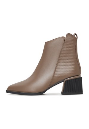Botte s kutom vrhom od glatkog taupe materijala s rebrastim bočnim akcentima i robusnom crnom petom. Tanka dizajn s elegantnom siluetom.