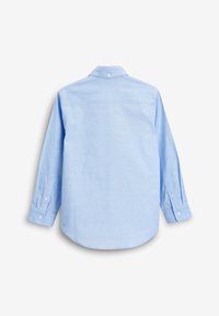 Chemise bleu clair à manches longues boutonnée, vue de dos avec des poignets boutonnés et un bouton au col sur fond blanc.