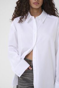 Λευκό πουκάμισο με κουμπιά και γιακά, με μακριά μανίκια και άνετη εφαρμογή. Ελαφρώς ξεκουμπωμένο, με ομαλή υφή και καθαρό σχεδιασμό.