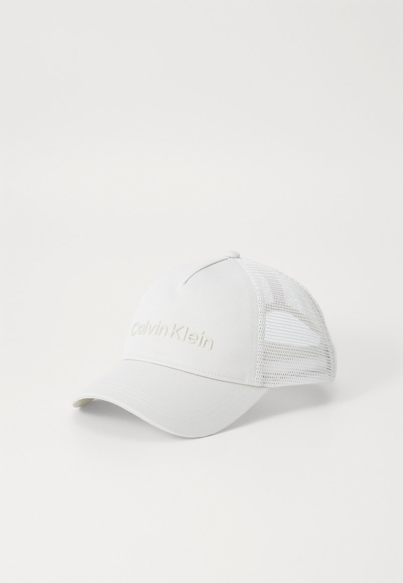 Valge beisbolikiiver, millel on struktureeritud esiosa ja võrkmaterjalist tagaosa. Omab diskreetset, tikitud "Calvin Klein" logo.