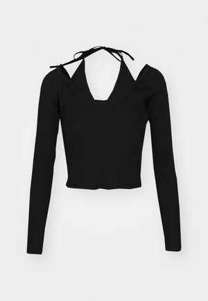 Svart ribbestrikket langermet topp med cropped hem, dyp V-hals og utskåret skulderdetalj, med knyttede stropper ved halsen.