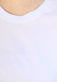 T-shirt bianco in cotone con scollo rotondo. Tessuto leggero e morbido con sottile costina; design leggermente aderente attorno al collo.