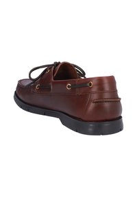 Zapato de cuero marrón con punta redondeada, diseño de cordones, costuras visibles y suela de goma negra. Presenta ojales dorados para los cordones.