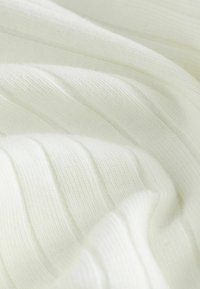 White knit fabric with a ribbed texture, showing soft, undulating folds. The material appears lightweight and smooth.