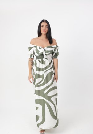 Groene en witte off-the-shoulder maxi-jurk met een smocked taille en abstract patroon; heeft korte pofmouwen en een gestrikt voorpaneel.