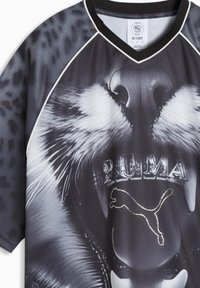 Sort og grå kortærmet skjorte med stort leopardansigt-grafik. "PUMA" logo og puma-silhuet i sølv-accenter. V-udskæring.