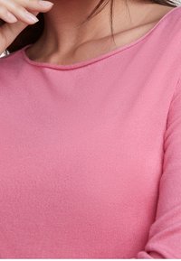 Roze geribbelde langemouwen top met een brede halslijn, een gladde textuur en een aansluitend ontwerp, met minimale stikseldetails.