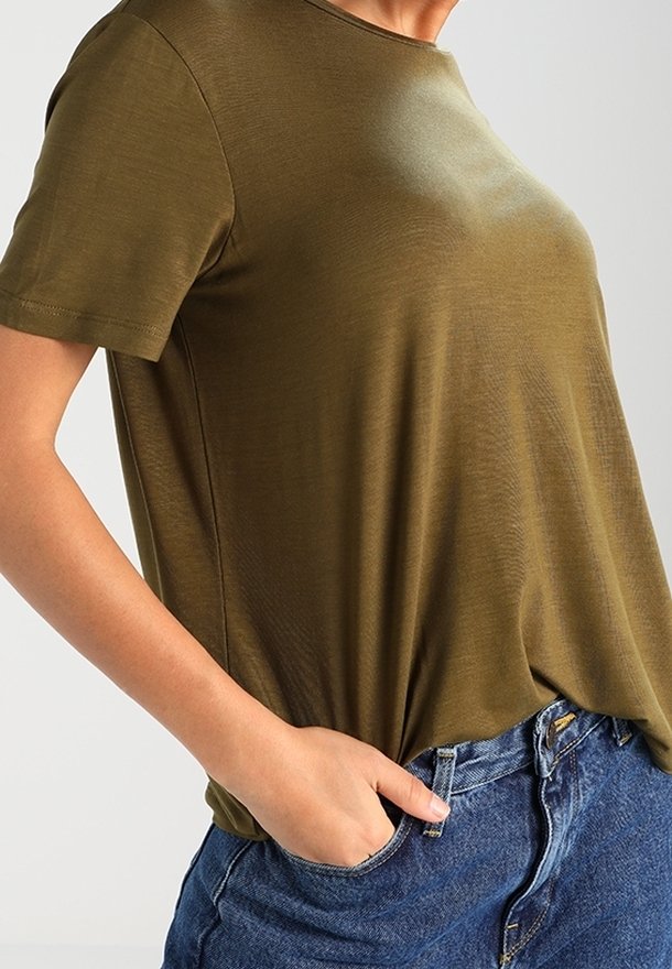 T-shirt verde oliva a maniche corte con scollo rotondo, tessuto liscio e vestibilità comoda, abbinato a pantaloni corti in denim blu.