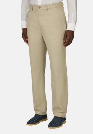 Beige Baumwollhose mit geradem Schnitt und subtiler Textur, ausgestattet mit einem vorderen Knopfverschluss und schrägen Seitentaschen.