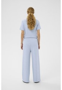 Hellblaues, gestricktes zweiteiliges Outfit mit kurzärmeligem Oberteil und weit geschnittenen Hosen, mit lockerem Schnitt und weicher Textur.