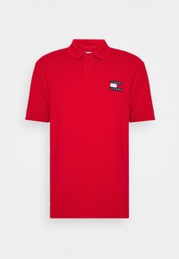 Rode polo shirt van katoen, met een twee-knopen sluiting en korte mouwen. Toont een marineblauw en wit 'TOMMY JEANS' logo patch op de borst.