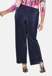 Navy pleatatut verkkohousut, jotka ovat sileäpintaiset ja joissa on valahtava muotoilu. Yhdistetty metallisiin nauhalautasiin.