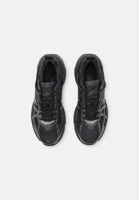 Svarta Nike-sneakers med ett mesh-övre, texturerade accenter, vadderad sula och snören med logotypdetalj på tungan och sidan.