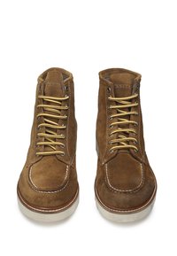Stivaletti in suede marrone con lacci gialli, dettagli cuciti, punta rotonda e suola in gomma bianca. Presenta un logo impresso sulla linguetta.