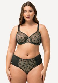Bralette en dentelle noire et culottes taille haute avec motifs floraux. Tissu en maille semi-transparente avec des accents noirs unis et un détail nœud au centre.