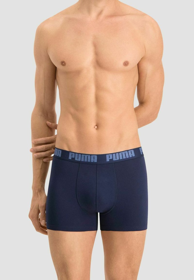 Navy blue boxer briefs made of soft fabric, featuring a contrasting light blue Puma logo on the elastic waistband. Fitted design.