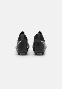 Scarpette da calcio nere e grigie con superiore testurizzato, loghi in evidenza e tacchetti moldati per aderenza, dal design elegante e aerodinamico.