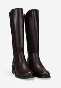 Botas de cuero marrón hasta la rodilla con un acabado suave, cierre de cremallera lateral y tacón grueso con un detalle de acento dorado.