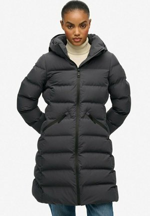 Black puffer jacket with a hood, featuring a zip-up front, side pockets, and a quilted pattern. Made from a smooth, insulated material.