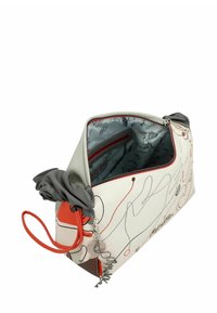 Große Tragetasche mit weißer Außenseite, die abstrakte rote und schwarze Linien zeigt. Graue obere Akzente, ein dekorativer Anhänger und eine innere Reißverschlusstasche.