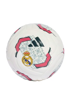 Balón de fútbol blanco de Adidas con diseños rojos y negros y el escudo del club Real Madrid en la superficie sobre un fondo blanco.
