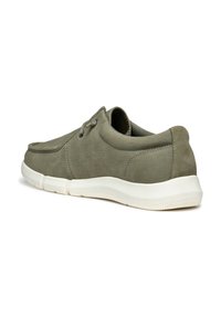 Zapatillas de ante verde con un diseño de perfil bajo, costuras tonales, cordones redondos y una suela de goma blanca. Textura suave y un detalle mínimo.