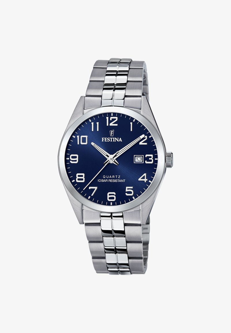 Sudraba nerūsējošā tērauda kvarca pulkstenis ar zilu ciparnīcu, lieliem baltiem stundu rādītājiem un datuma displeju. Aprīkots ar posma aproci un ir ūdensizturīgs līdz 10 bāriem.