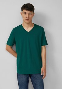 Groene v-hals t-shirt van katoen met korte mouwen, met een rechte zoom en subtiele logo-detail aan de linkerkant van de borst.