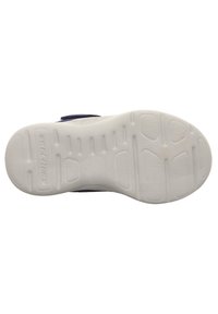 Suela de zapato Skechers con una superficie de goma texturizada blanca, que presenta un dibujo en el relieve y una parte superior de tela en color marino visible a lo largo del borde.