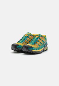 Scarpe sportive blu e gialle con una tomaia testurizzata, design a motivo, punta arrotondata e suola nera robusta per una maggiore aderenza.