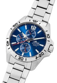 Reloj de acero inoxidable con una esfera azul, marcadores plateados y tres subesferas. Cuenta con una función de fecha y una pulsera de eslabones metálicos.