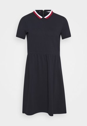 Robe noire à manches courtes avec jupe évasée et fermeture éclair au dos, dotée d'un col rayé rouge et blanc avec détails en sequins.