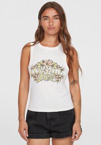 Vit ärmlös bomullstopp med en färgglad blommig grafisk design med texten "Surf Co." i livfulla färger. Bärs med svarta shorts.