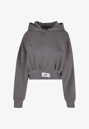 Szürke, rövidített kapucnis pulóver, puha anyagból készült, húzózsinórral ellátott kapucnival, oversized ujjakkal és bordás derékrésszel, amelyen egy kis címke részlet található.