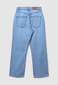Pantalon en denim bleu avec une coupe évasée, présentant une taille haute, deux poches arrière et une étiquette en cuir à l'arrière.
