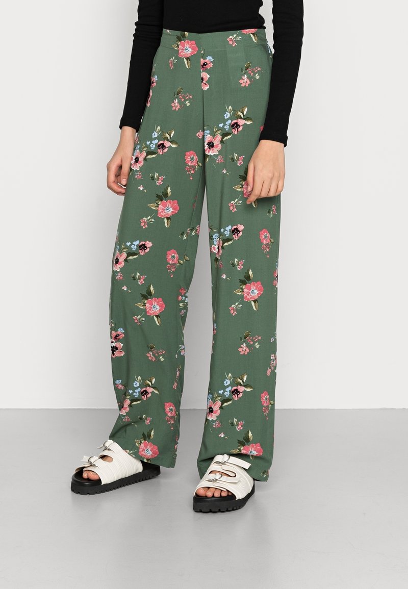 Bloemige wijde broekspijpen in groen met roze en blauwe bloemen. Gemaakt van lichtgewicht stof, met een hoge taille en een losse pasvorm.