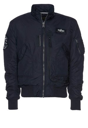 Veste bomber bleu marine avec fermeture éclair à l'avant, deux poches inclinées, poignets et ourlet côtelés, et patchs sur la poitrine et la manche gauche.