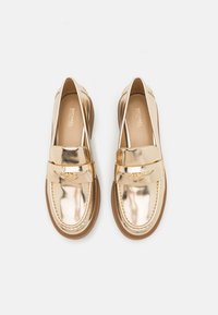 Gouden metallic leren loafers met een platte zool, voorzien van een voorband en logo-accent. Ronde neus en stikseldetail.