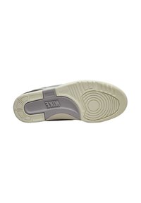 Talpa de sneaker Nike cu o bază albă, secțiune din cauciuc texturat de culoare gri, modele circulare și liniare, și detaliu cu logo embosat.