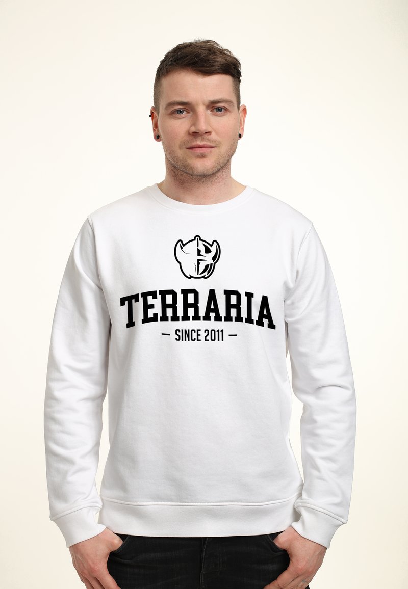 Hvid sweatshirt med lange ærmer, der har et sort trykt logo og teksten "TERRARIA SINCE 2011" på forsiden. Glat tekstur.
