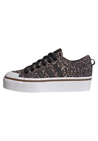 Baskets à imprimé léopard en rose et noir, dotées de lacets noirs, d'un embout en caoutchouc blanc et d'une épaisse semelle blanche avec un accent marron.