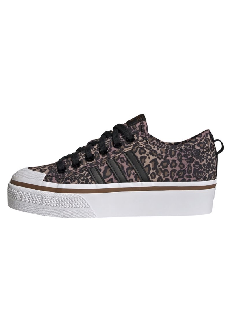 Baskets à imprimé léopard en rose et noir, dotées de lacets noirs, d'un embout en caoutchouc blanc et d'une épaisse semelle blanche avec un accent marron.