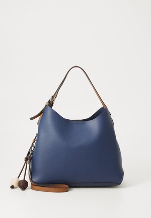 Blauwe leren handtas met een bruine verstelbare riem en decoratieve houten kralen aan koordjes, geplaatst tegen een effen witte achtergrond.