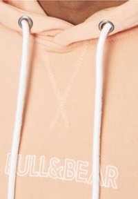 Felpa in cotone rosa con cappuccio, dotata di coulisse, occhielli argentati e ricamo bianco del logo sul davanti. Texture liscia con vestibilità rilassata.